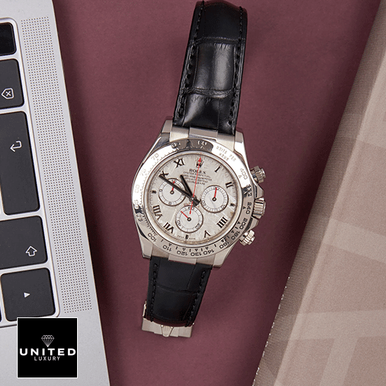 Rolex Daytona 116519 White Roman Dial Replica 6 Rolex Daytona 116519 Stainless Steel Case Black Leather Replica on the table