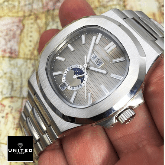Patek Philippe Nautilus Black Dial Replica 2 Patek Philippe Natilus Grey Dial Moon Steel Replica on the hand map background